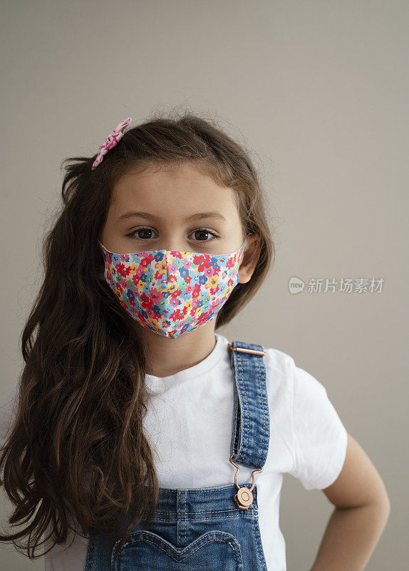 Portrait of 8 year old cute girl wearing homemade protective mask during quarantine
